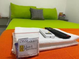 里奥阿查Hotel Aventura Riohacha的毛巾上带遥控器的床