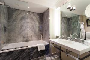 伦敦The Capital Hotel, Apartments & Townhouse的一间带水槽、浴缸和镜子的浴室