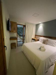 莫罗圣保罗Terra Bella Pousada的卧室设有一张白色大床和一扇窗户。