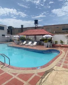 里奥阿查Hotel la Sierra Riohacha II的一个带椅子和凉亭的大型游泳池