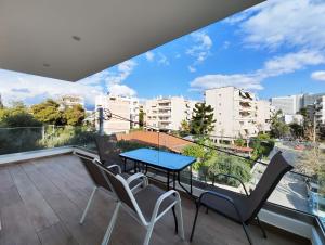 雅典Marathonomachon Apartments by Verde Apartments的阳台配有蓝色的桌椅