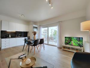 雅典Marathonomachon Apartments by Verde Apartments的厨房以及带桌椅的起居室。