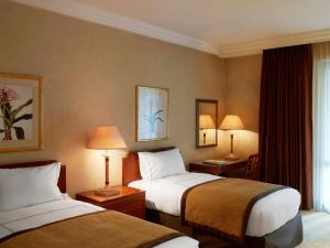 亚的斯亚贝巴Sheraton Addis, a Luxury Collection Hotel, Addis Ababa的酒店客房设有两张床和窗户。