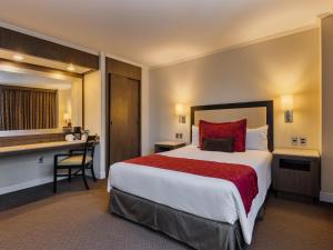 墨西哥城Exe Alameda Reforma的酒店客房设有一张大床和一张书桌。