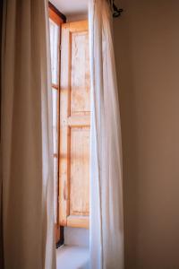 AgreloPosada Finca Garciarena的前方有窗帘的开放式窗户