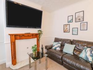 哈特尔普尔Hartlepool Heaven的客厅配有棕色真皮沙发和平面电视。
