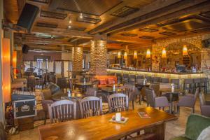 Kalyvia阿约利德斯酒店的一间带桌椅的餐厅和一间酒吧