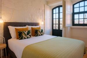 波尔图AgapeStay Porto的一间卧室设有一张大床和两个窗户。
