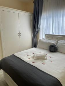 哈拉雷@Jackie’s Avondale 2 bed flat at Harrow court的一张白色的床,上面有红色的鲜花
