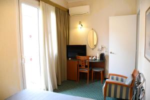 雅典阿德里安酒店的酒店客房配有一张床和一张带镜子的书桌