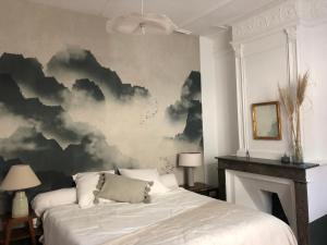 AspiranChambres d'hôtes La Tour d'Aspiran的一间卧室,配有一张床,画着云彩画