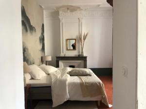 AspiranChambres d'hôtes La Tour d'Aspiran的一间卧室配有一张带镜子的床和壁炉