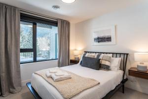 雷夫尔斯托克Peaks and Birdies by Revelstoke Vacations的一间卧室设有一张床和一个大窗户