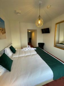 奥德斯希尔德Havenhotel At Sea Texel的卧室内的一张白色大床,配有吊灯