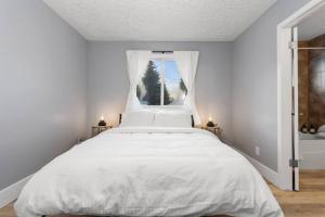 埃德蒙顿Elegant Boho Retreat - 8 min to WEM的白色卧室设有一张大床和窗户