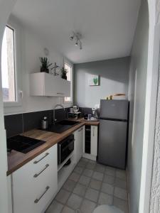 格雷乌莱班studio meublé classé 2 étoiles - 30m²的小厨房配有白色橱柜和冰箱。