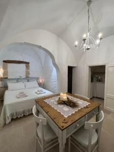 奥斯图尼Dimora L’Antico Bijou的一间卧室配有一张床和一张带蜡烛的桌子