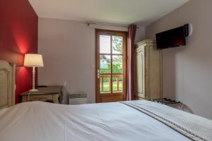 图尔尼Hotel Village Motel的卧室配有白色的床和窗户。