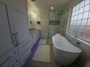 奥斯汀Cozy modern house - Near SXSW and other events的白色的浴室设有浴缸和水槽。