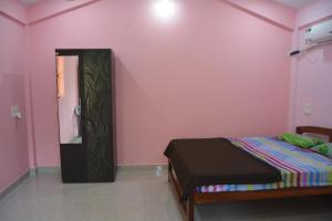 莫尔吉姆chill out home morjim的一间卧室配有一张床和粉红色的墙壁