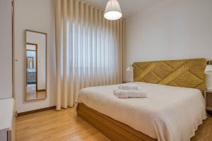 马亚Spacious House in Porto for family and friends的一间卧室配有一张床,上面有两条毛巾