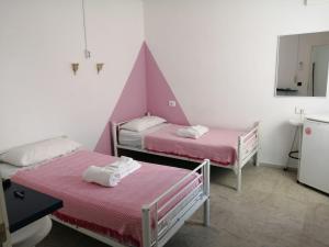 伊维萨镇Coordenadas Ibiza的客房设有2张带粉红色床单和镜子的床。