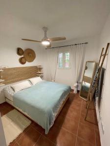卡内拉岛Charming apartment, golf, kitesurfing, free tennis courts and bikes的一间卧室配有一张床和吊扇