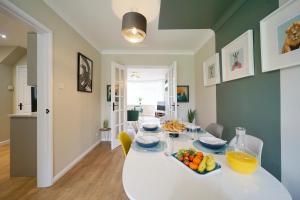 MoortownStunning luxury 3 bed house with garden in North Leeds的一间用餐室,配有带水果的白色桌子