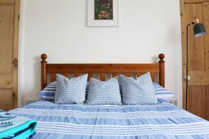 BigburyCosy Beachside Cottage的蓝色和白色的床,配有蓝色和白色的枕头