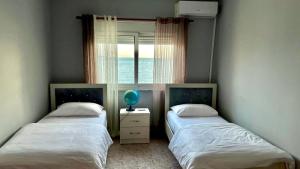 都拉斯Sea View Apartaments的带窗户的客房内设有两张单人床。