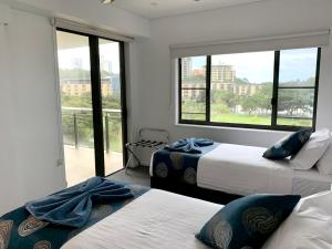 达尔文Serenity Splendour at Darwin Waterfront的一间卧室设有两张床和大窗户