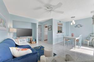 布雷登顿海滩Coastal Cheer的一间带蓝色沙发的客厅和一间用餐室