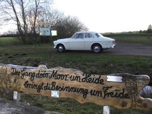 RehdenKranich-Holzferienhaus 'Kleine Auszeit'的停在标志旁的田野上的白色汽车