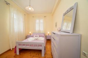 阿索斯House of Hapiness in Assos的一间卧室配有带梳妆台的床和电视。