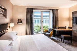 杜塞尔多夫杜塞尔多夫机场谢拉顿酒店的配有一张床、一张书桌和一扇窗户的酒店客房
