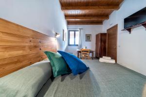 阿夸维瓦德莱丰蒂Agriturismo Tenuta del Grillaio的一间卧室配有一张带大型木制床头板的床