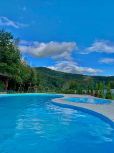 索洛钦Saliuk Lodge的一个蓝色的海水和山脉背景的游泳池