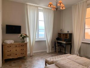 坎诺比奥Spiaggia Amore - Appartamenti Vacanza Vista Lago的一间卧室配有一张床、一张书桌和一台电视
