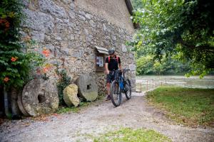 Stari Trg ob KolpiMadronič family estate - Kolpa river的骑着自行车在石头建筑旁边的人