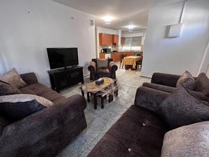 伯利恒Naji's House in Bethlehem-Full apartement的带沙发、电视和桌子的客厅