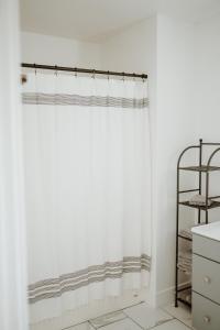 特罗皮克Happy Trails West Inn的浴室内有白色的浴帘,有架子
