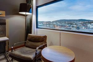 奥斯陆奥斯陆斯堪的纳维亚丽笙酒店的窗户房间里一张椅子和一张桌子