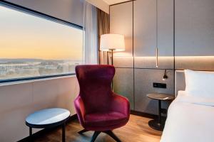 奥斯陆奥斯陆斯堪的纳维亚丽笙酒店的酒店客房设有红色椅子和窗户。