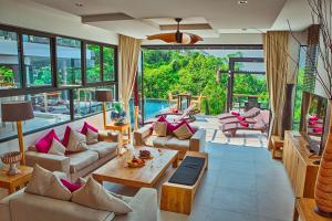 邦涛海滩Fully Serviced Grand Villa Luxury Time Phuket的客厅配有家具和大窗户。