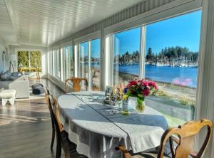 BowserThe Beach House at Deep Bay的一间设有一张桌子并享有水景的用餐室