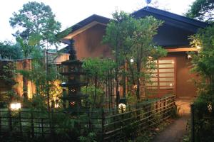 佐野市Rokugatsu-no-Mori Auberge的前面有围栏的房子