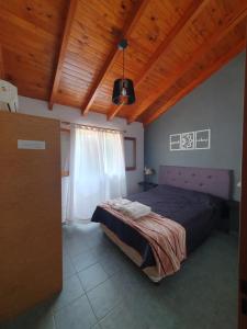 维拉卡洛斯帕兹Cabañas Andaluhe的一间卧室设有一张床和木制天花板