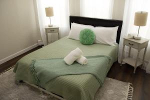 EverettCozy Getaway的一间卧室配有带两个枕头的绿色床