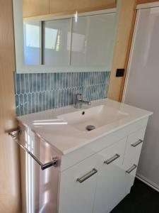 凯特里特里Kaiteriteri Tiny Home的浴室设有白色水槽和镜子