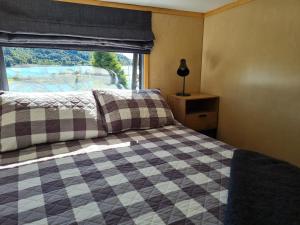 凯特里特里Kaiteriteri Tiny Home的一间卧室设有一张可调节的床和一扇窗户。